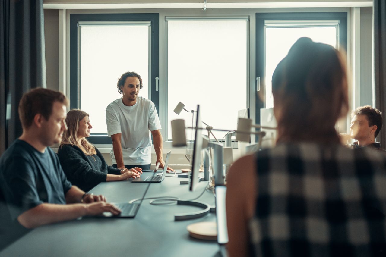 Une équipe diversifiée échange lors d’une réunion collaborative au bureau.