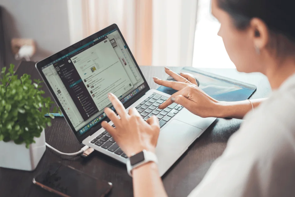 Three businesswomen collaborate with graphs and a laptop in a modern office setting.